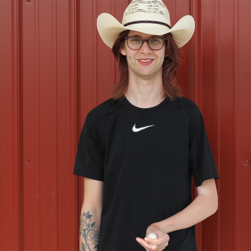 Intern posing for a picture next to the hay barn.