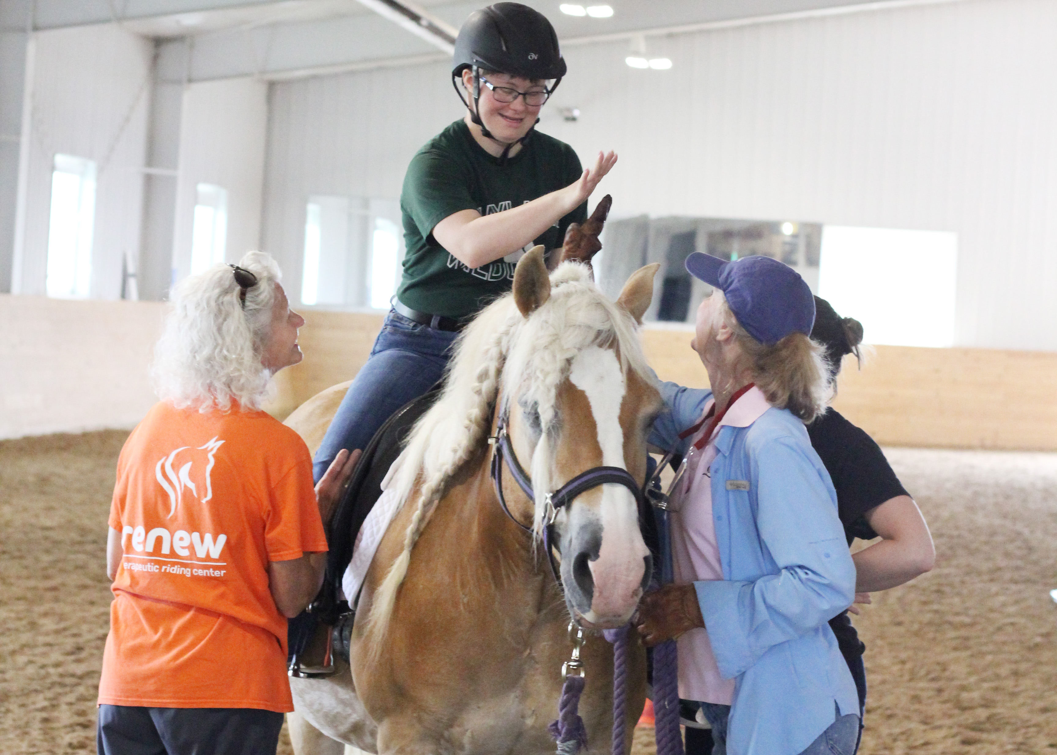 Student gives volunteers high five during lesson on Nobie.