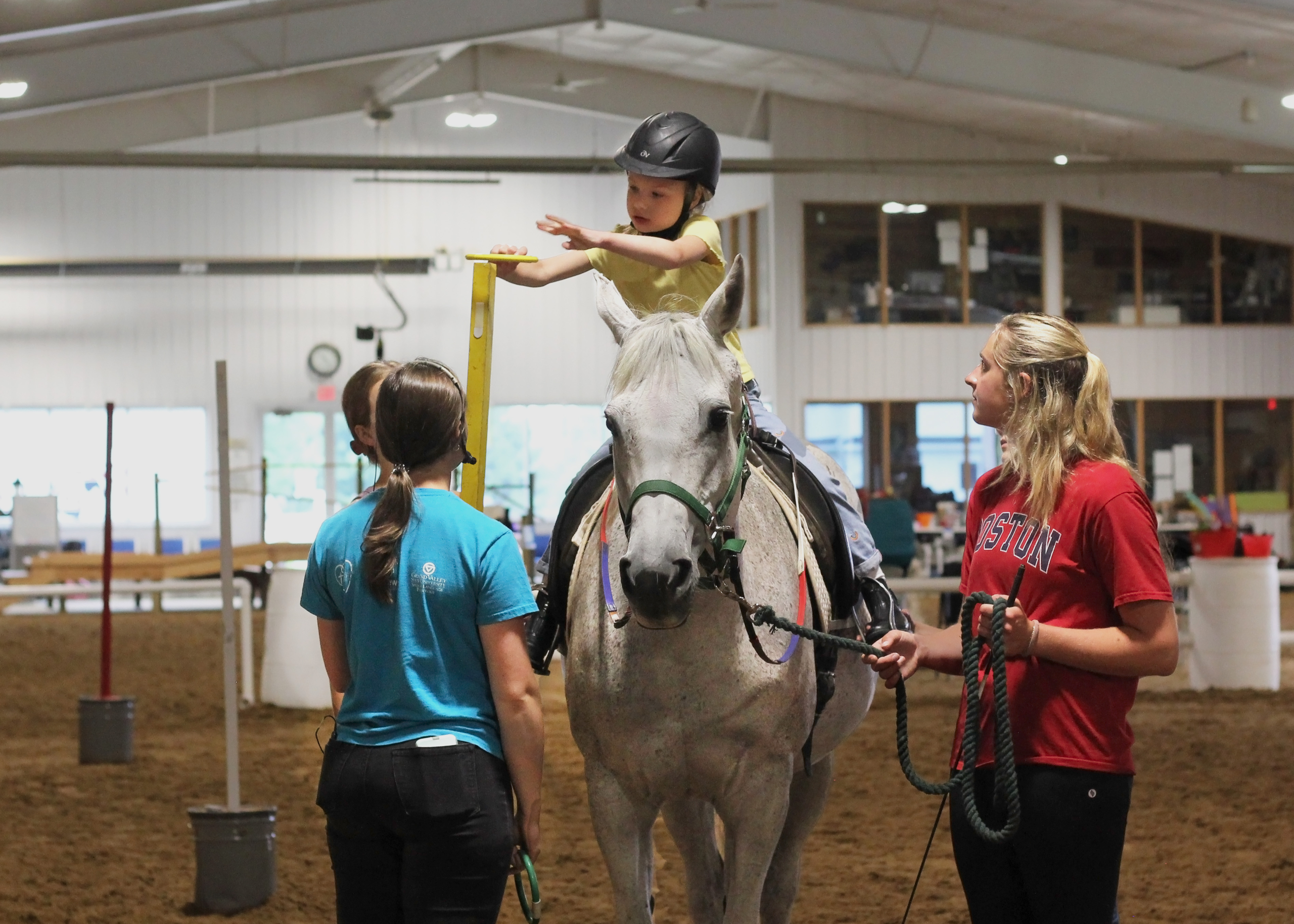 Student works on mastering many different skills at once through a game during her therapeutic riding lesson.